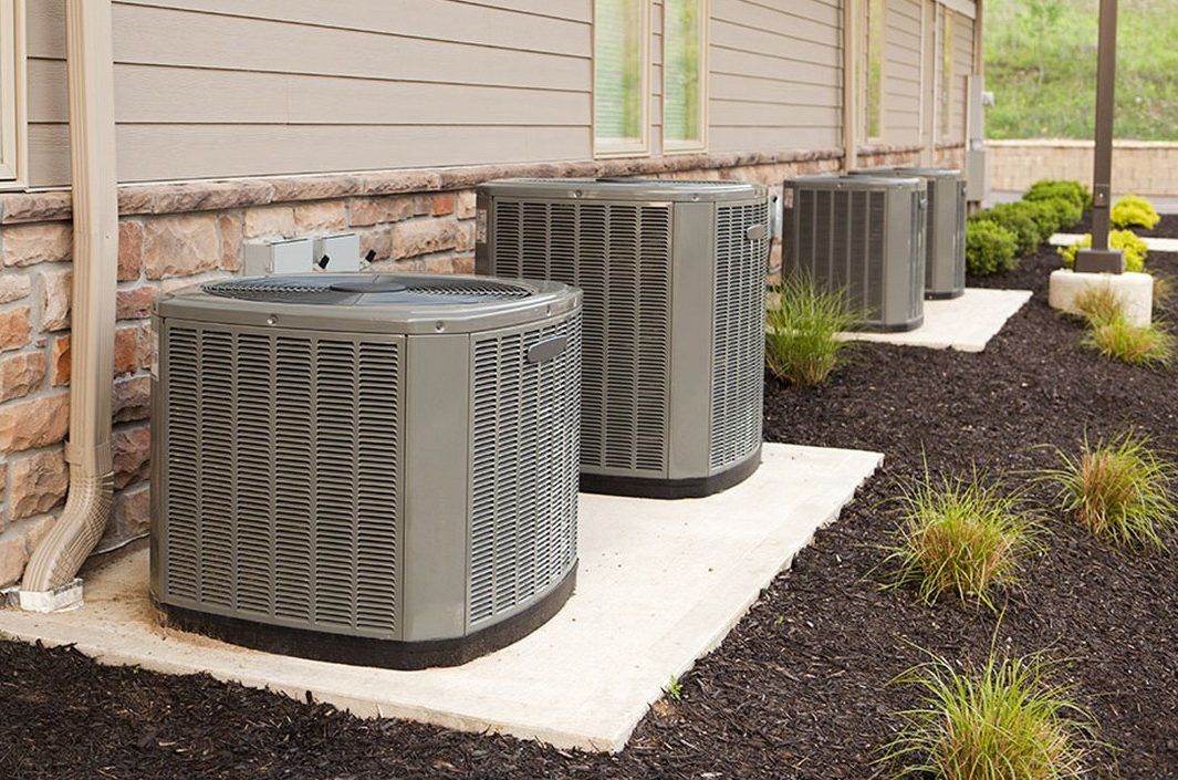 Four AC units outside a home.